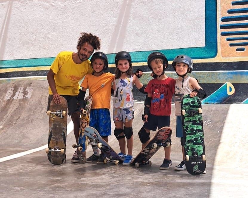Crianças de capacete com o instrutor depois da aula de skate na Pipa
