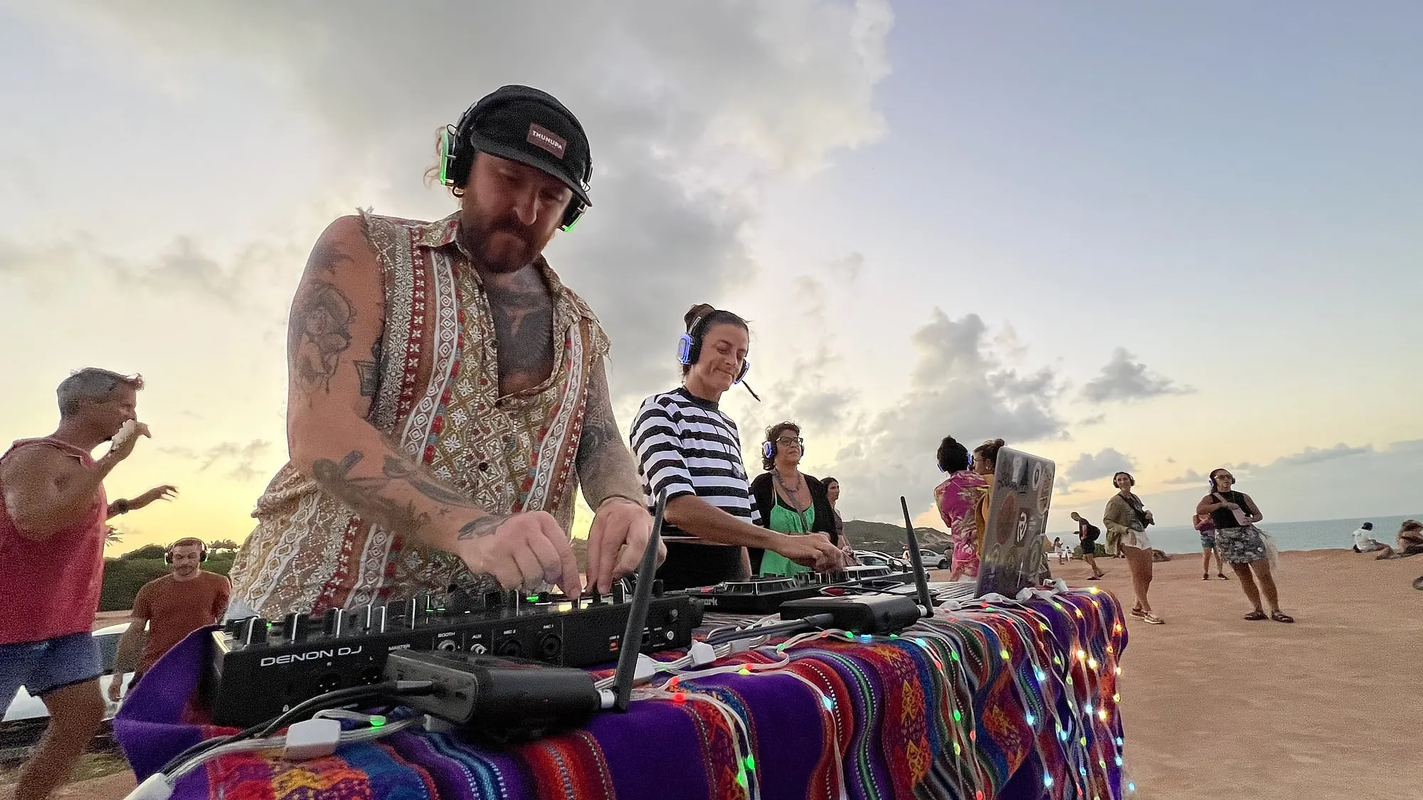 DJ tocando ao pôr do sol em edição da silent disco do Deixa Quieto Sound System, em Pipa