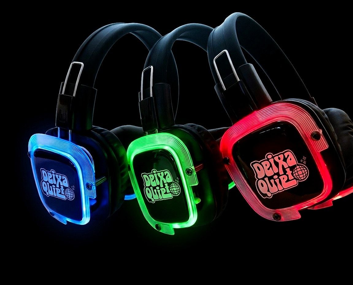 Três fones de silent disco do Deixa Quieto Sound System acesos em azul, verde e vermelho