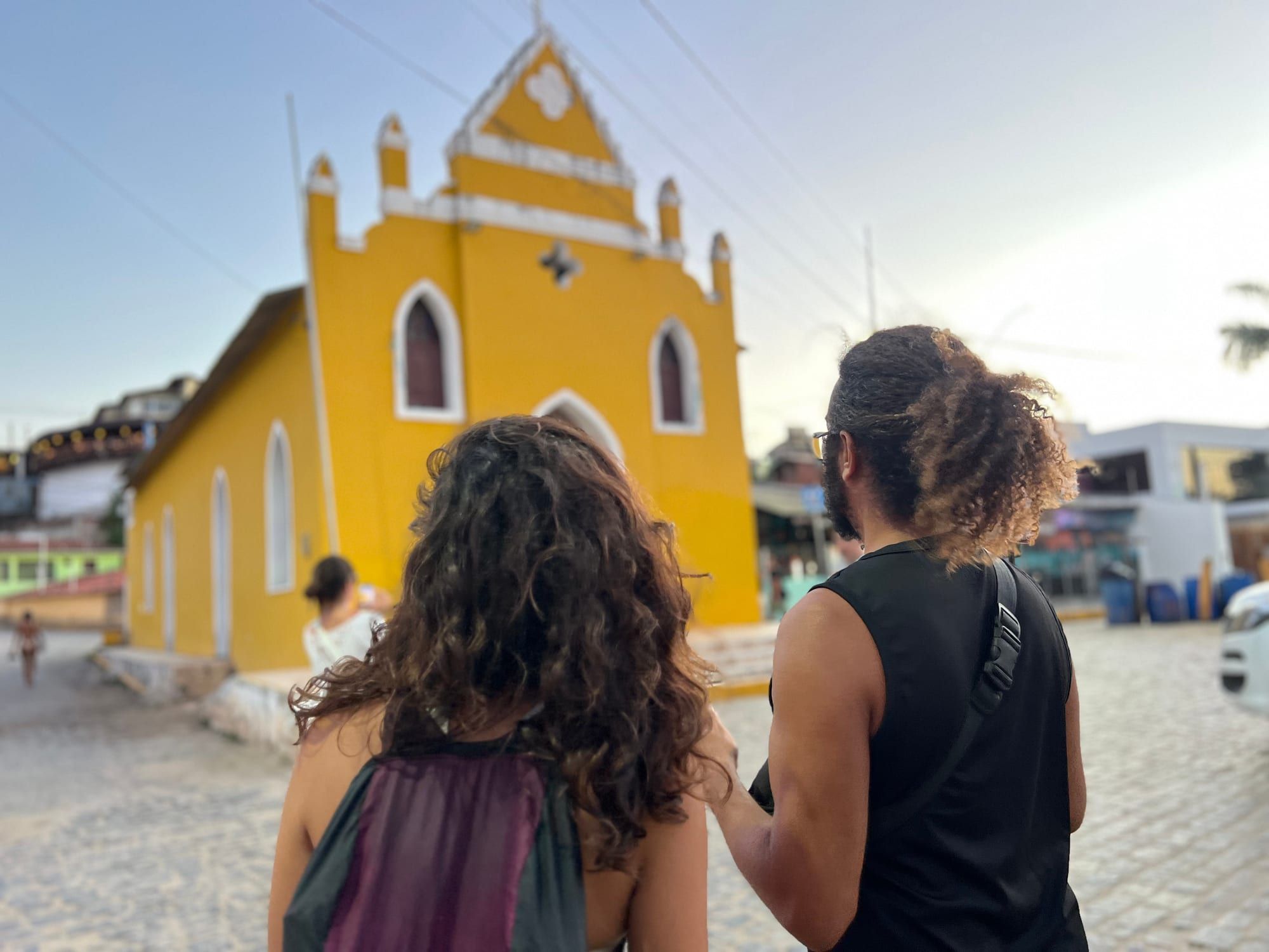 Viajantes diante da igreja amarela durante o City Tour Pipa Sunset